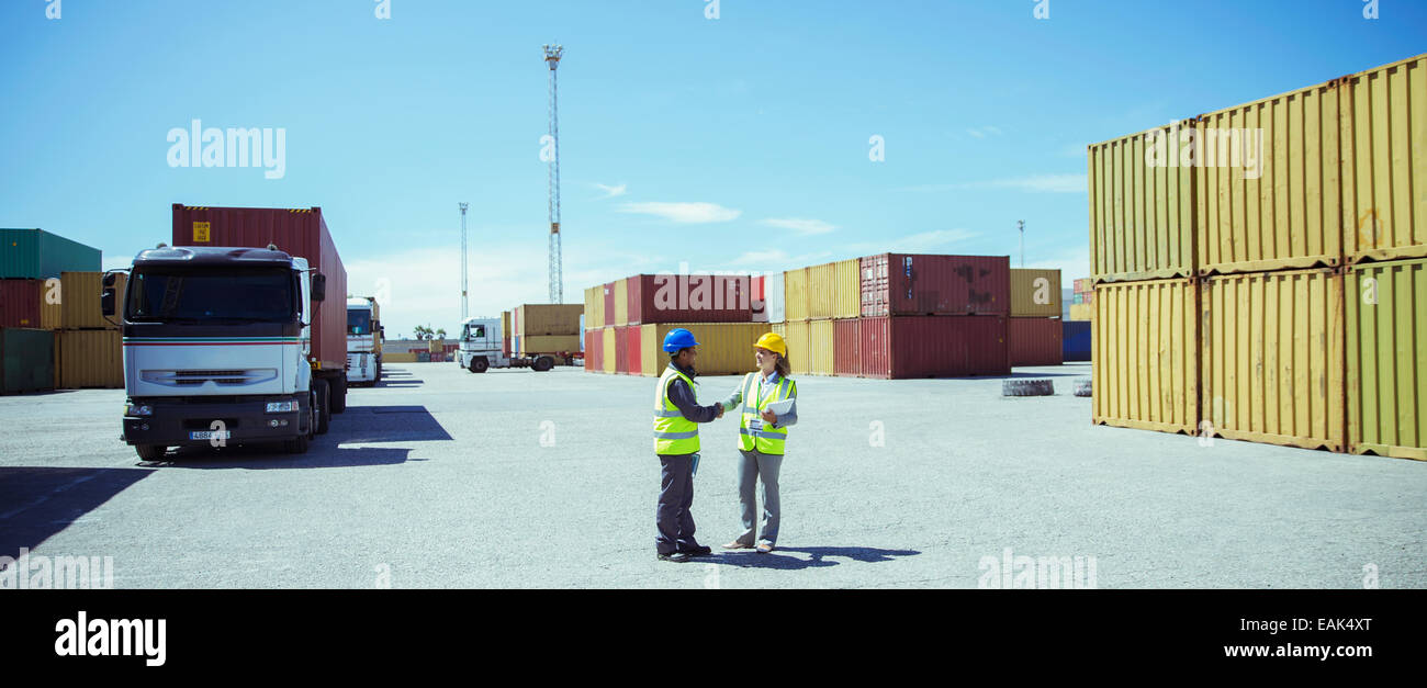 Arbeitnehmer, die in der Nähe von Containern im Gespräch Stockfoto