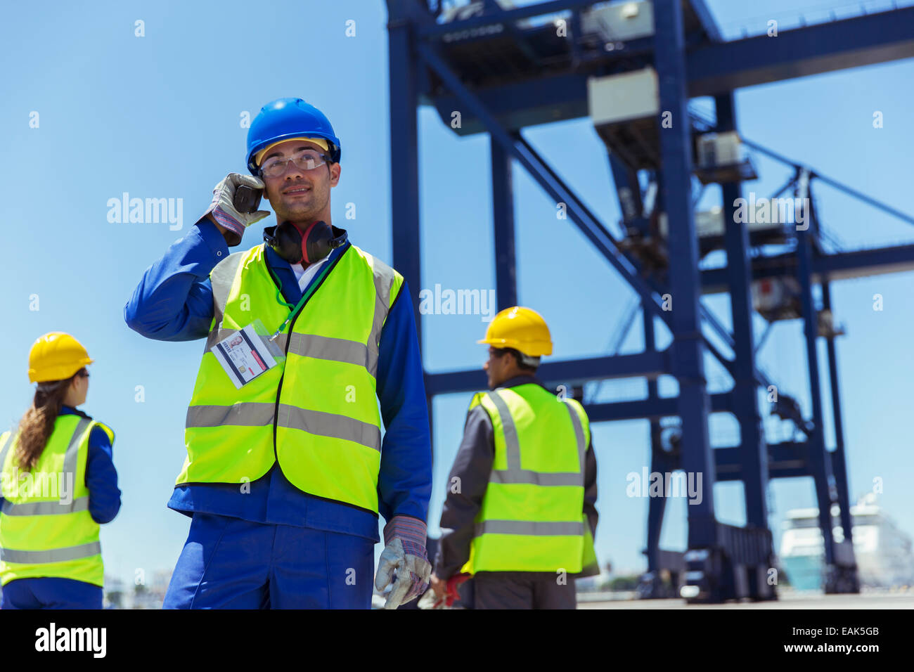 Arbeiter mit Walkie-talkie in der Nähe von Fracht Kran Stockfoto