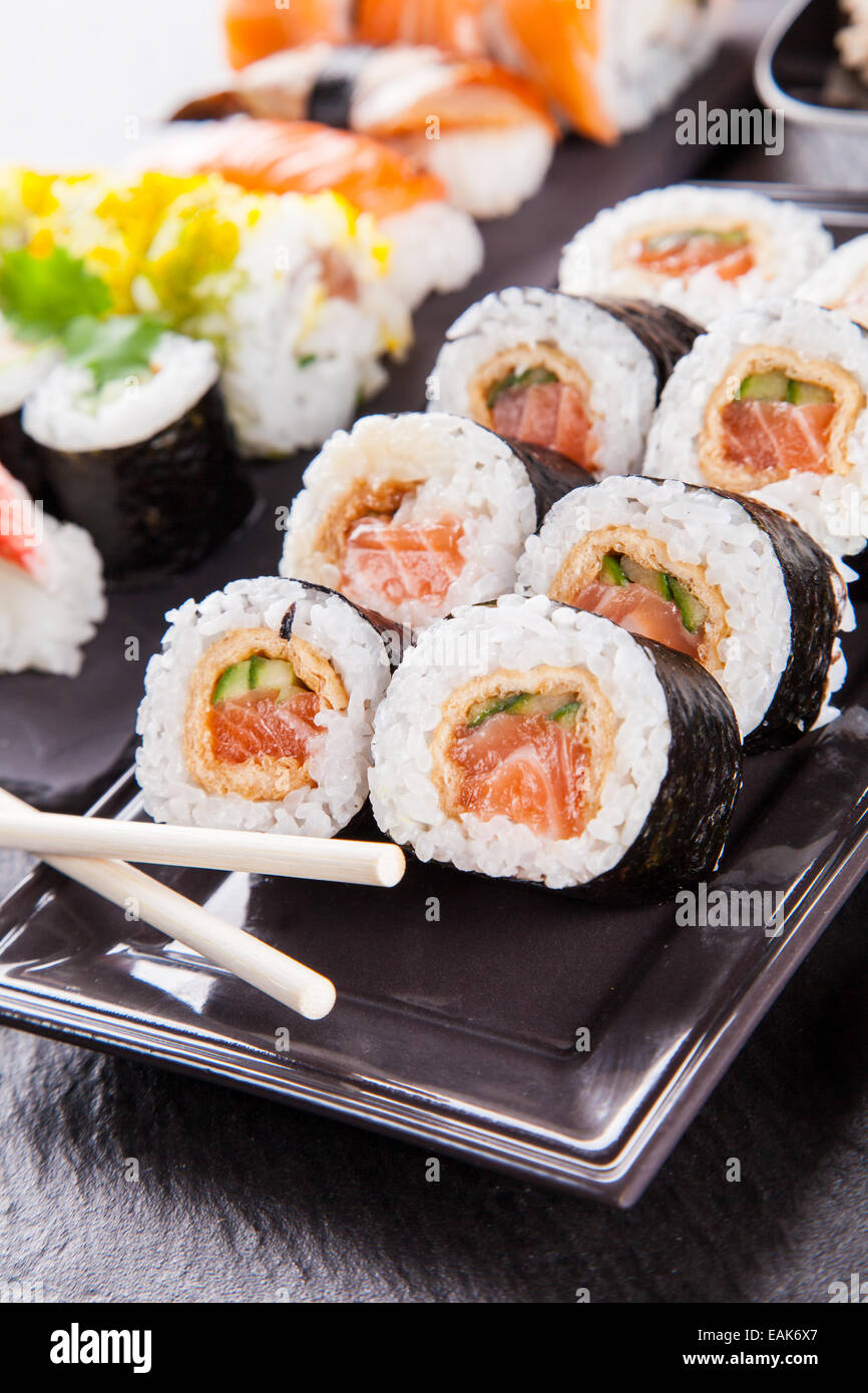 Verschiedene Arten von Sushi Essen serviert auf schwarzem Stein Stockfoto