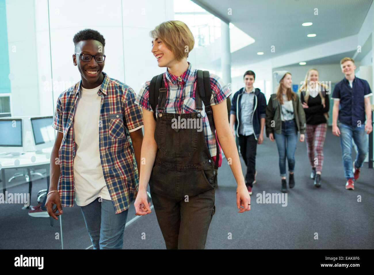 Gruppe von Studenten im Flur spazieren und lächelnd Stockfoto