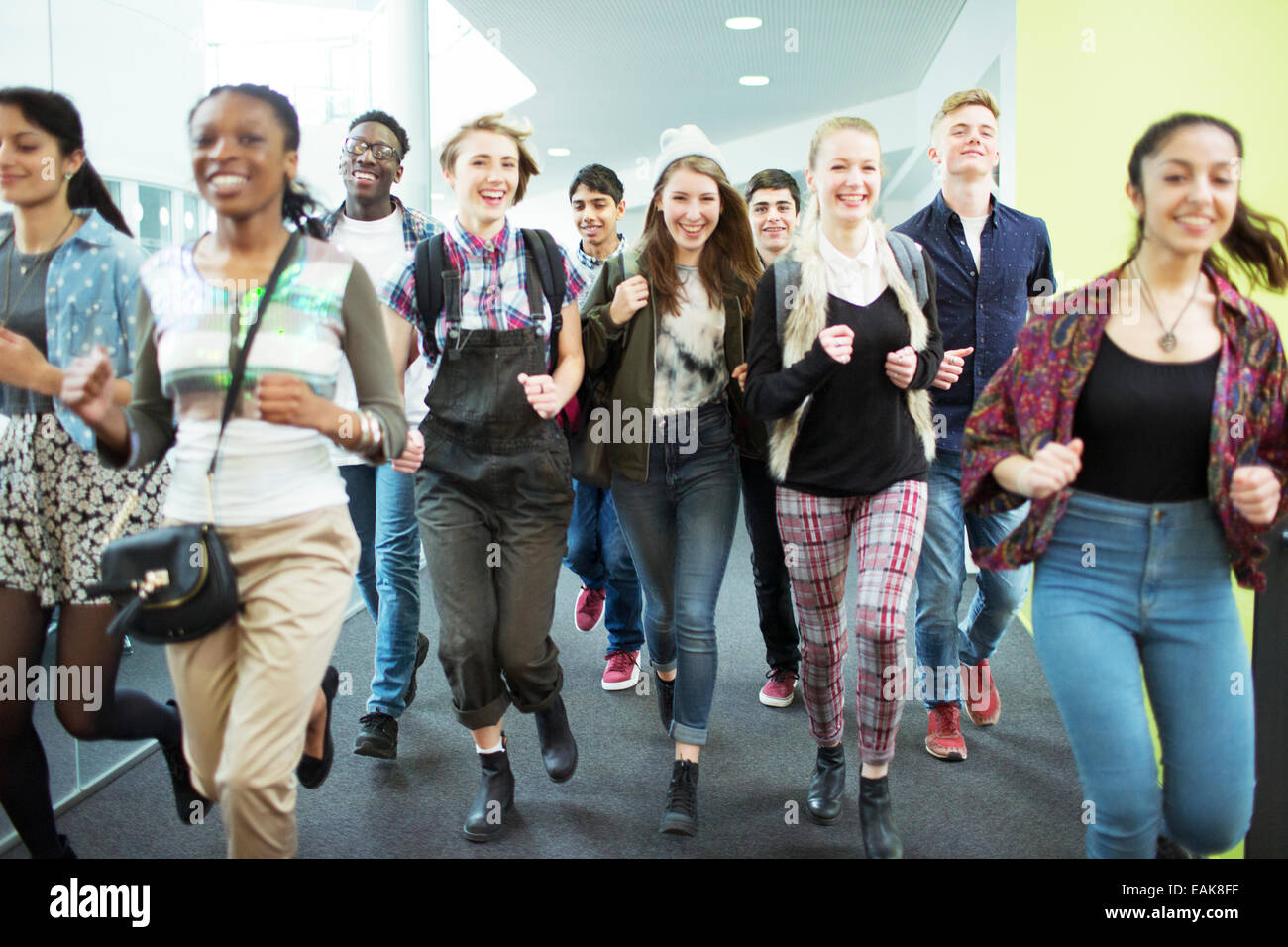 Gruppe von fröhlichen Studenten im Flur laufen Stockfoto