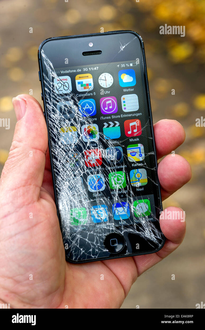 Smartphone, iPhone 5, mit gebrochenen Bildschirm, von einer Hand gehalten Stockfoto