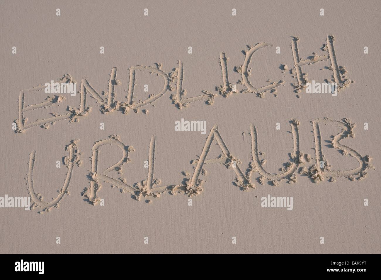 Schreiben in den Sand "Vergütungspolitik Urlaub", Deutsch für "endlich Urlaub" Stockfoto