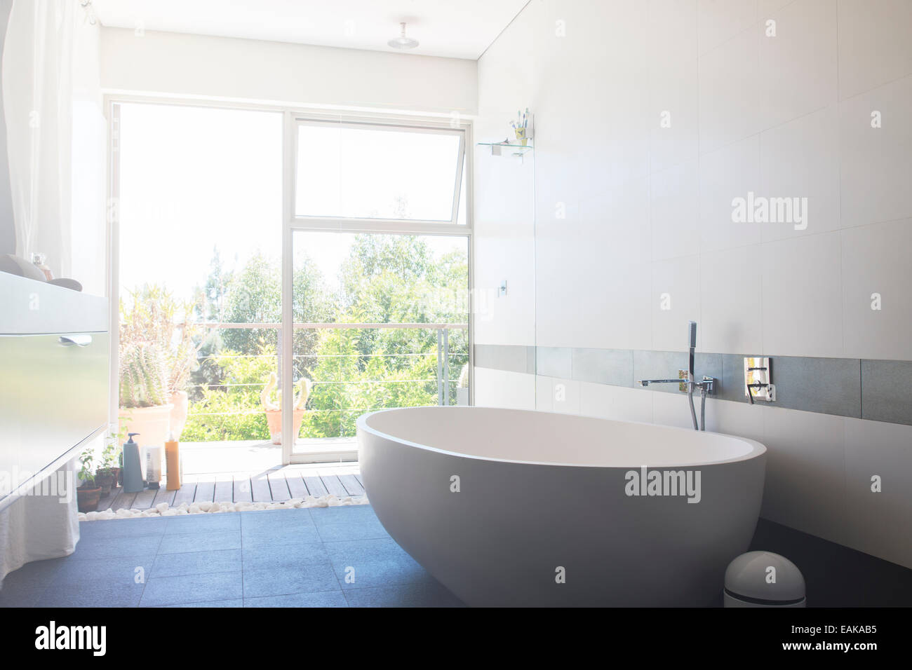 Modernes Badezimmer mit großen weißen Badewanne und Terrasse Tür Stockfoto