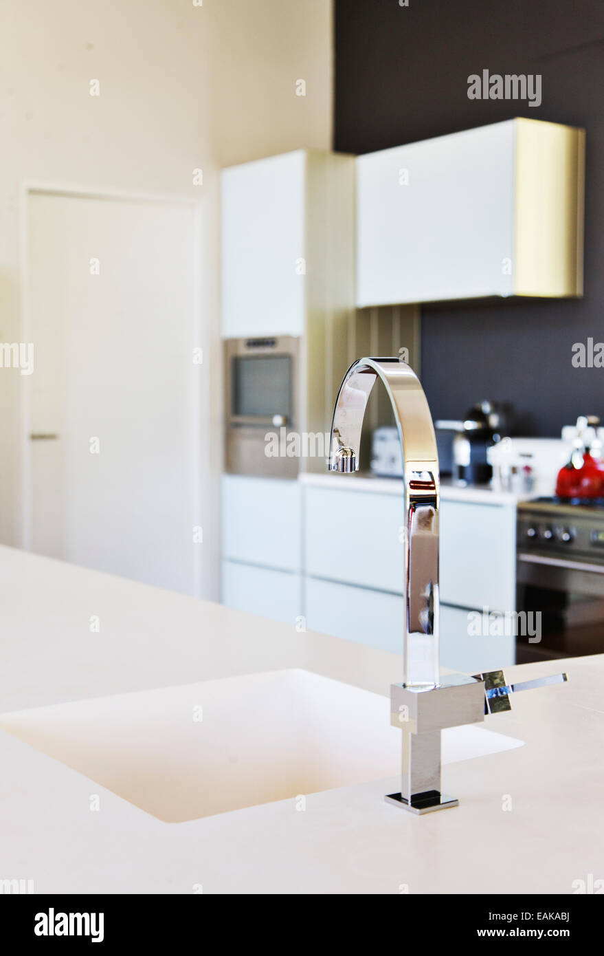 Moderne Edelstahl Wasserhahn und weiße Küche Waschbecken in saubere Küche Stockfoto