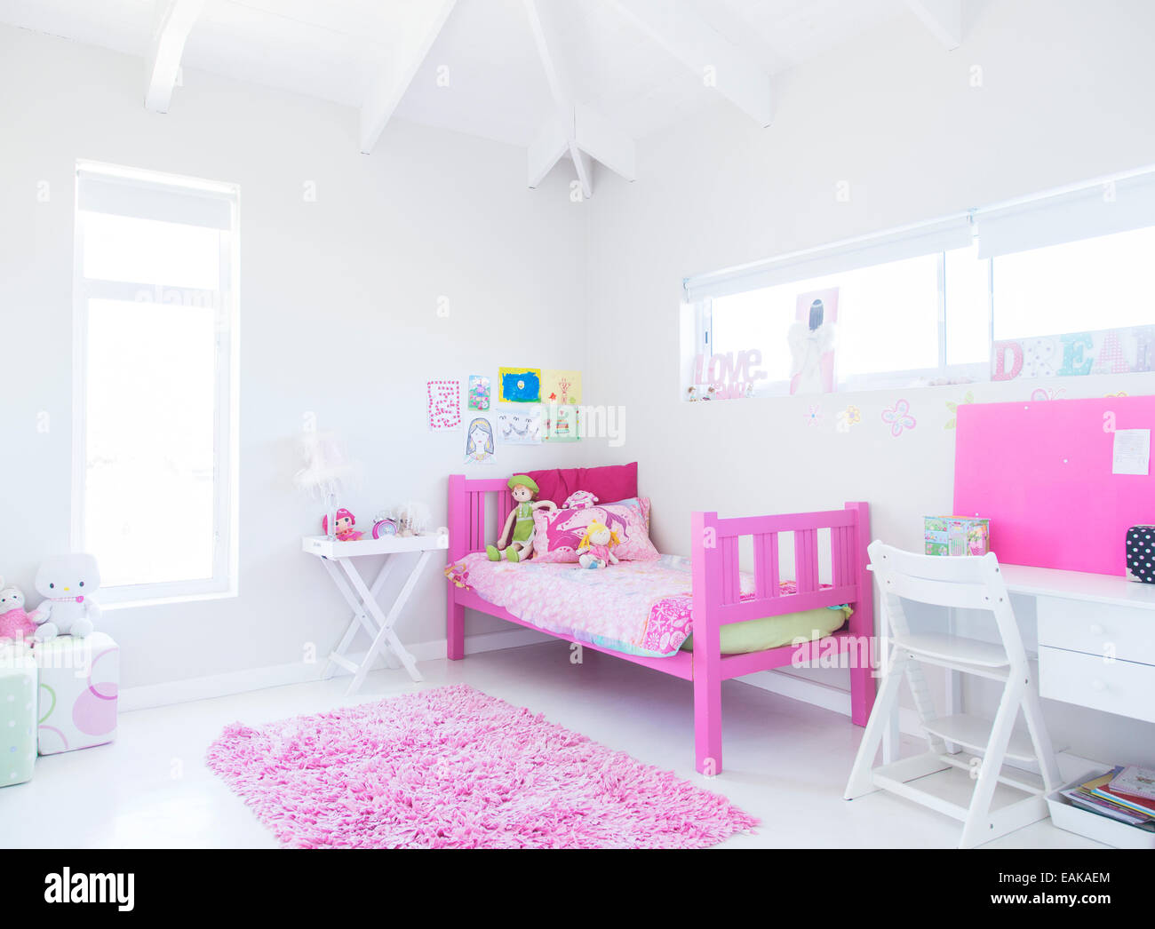Mädchenzimmer mit rosa Bett, Teppich und Spielzeug Stockfoto