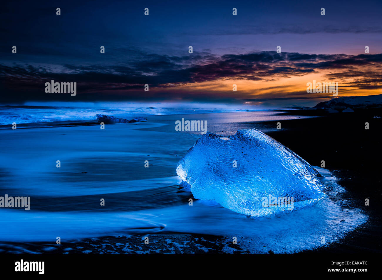 Klumpen des Eises am schwarzen Lavasand Strand zur blauen Stunde, See Jökulsárlón, Vik, Island Stockfoto