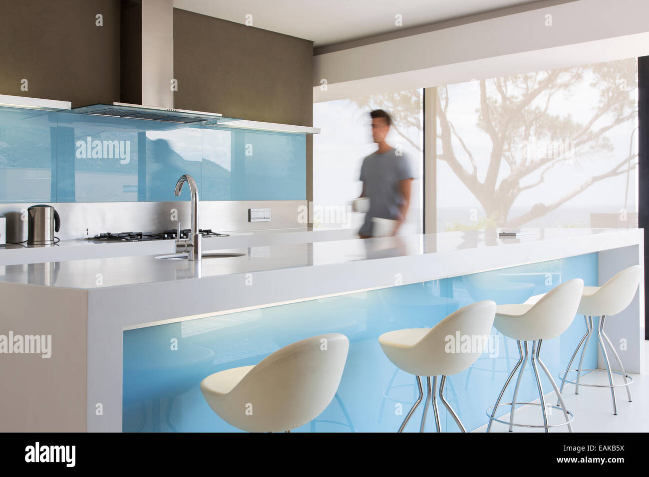 Bewegungsunschärfe Mann zu Fuß durch weiße, blaue und moderne Küche Stockfoto