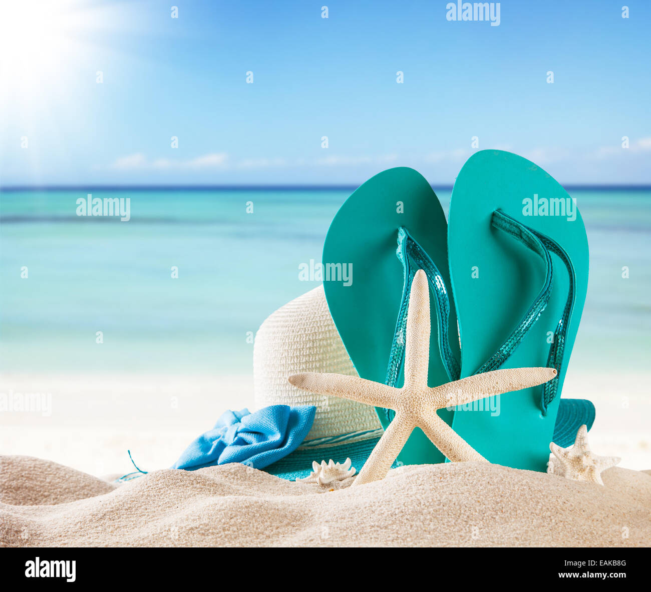 Sommer-Konzept mit Sandstrand, Muscheln und blaue Sandalen Stockfoto