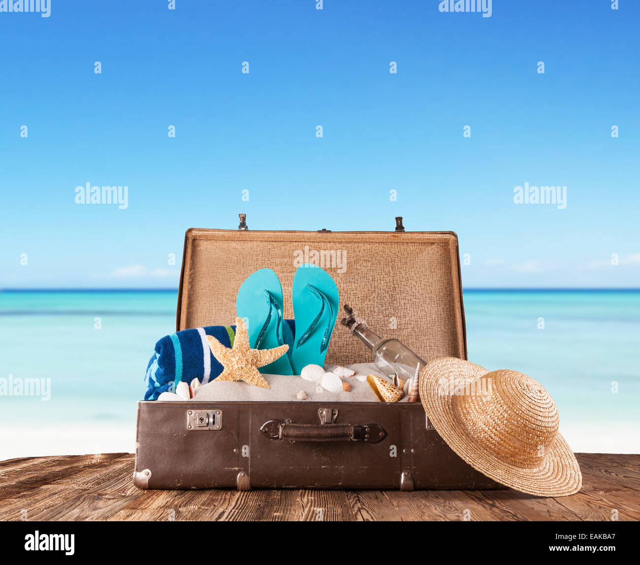 Konzept des Sommers Reisen mit alten Koffer und Zubehör. Strand auf Hintergrund Unschärfe Stockfoto
