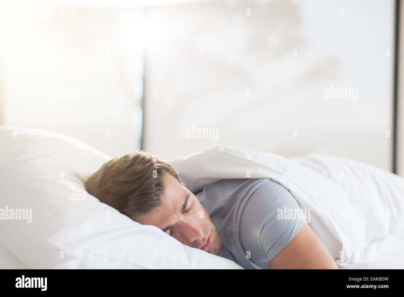 Junger Mann im Bett schlafen Stockfoto