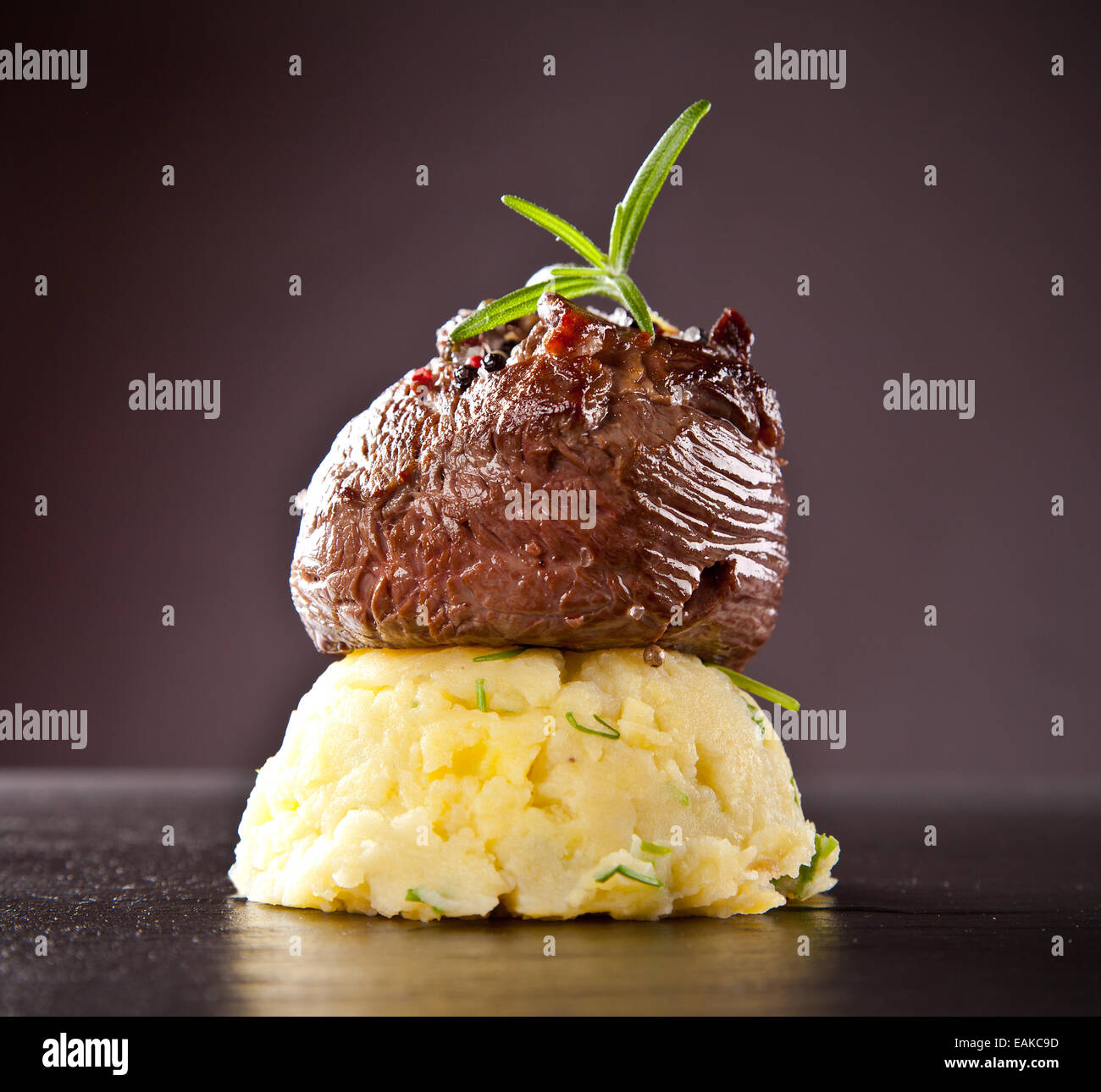 Stück rotes Fleisch Steak mit Kartoffel-Brei, serviert auf schwarzem Steinoberfläche. Stockfoto