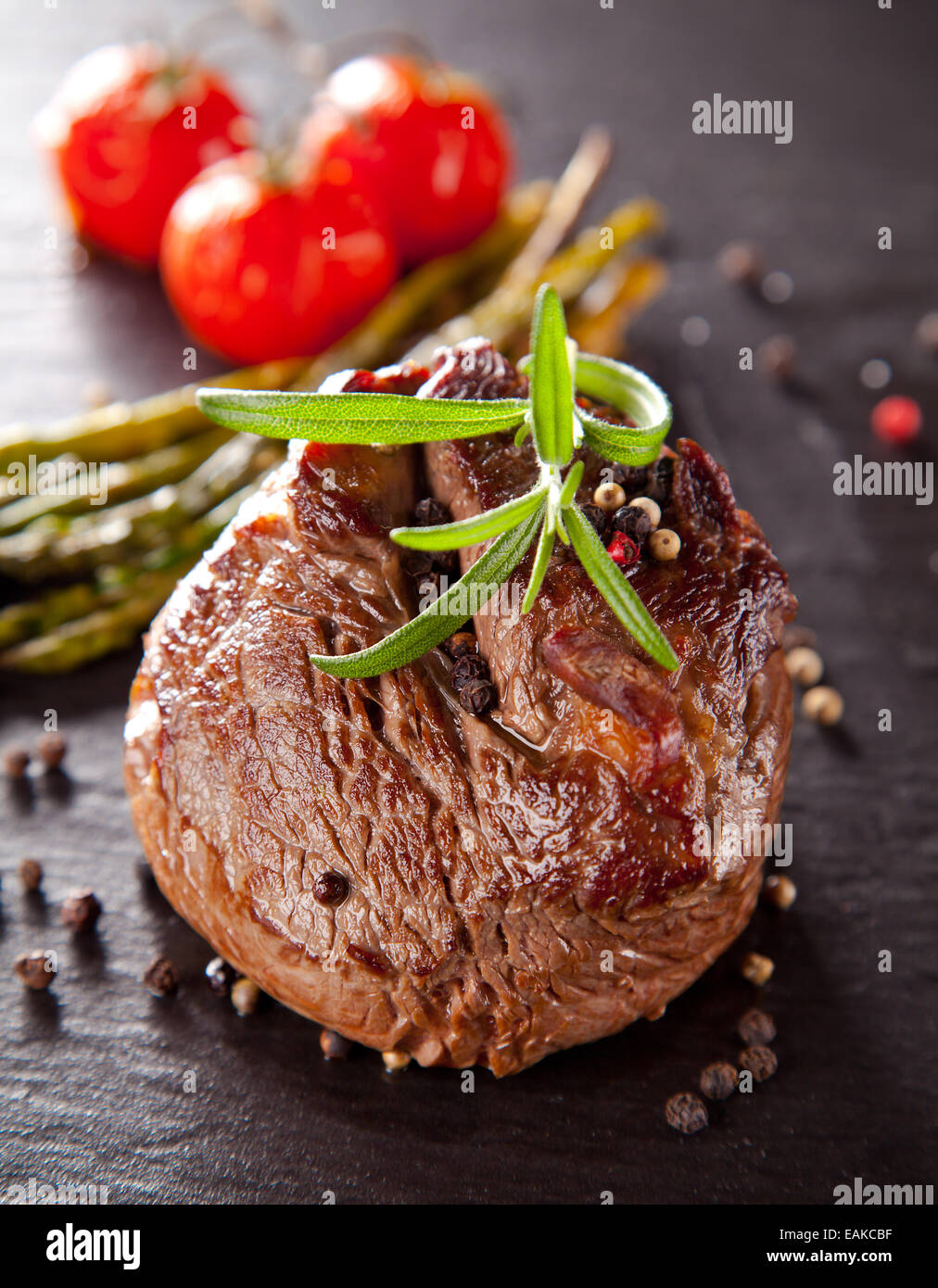 Rindersteak, serviert mit gegrilltem Gemüse und Kräuter auf schwarzen Steintisch Stockfoto