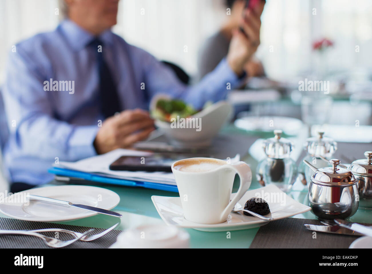 Nahaufnahme von Kaffeetasse am Tisch im Restaurant, Mann im Hintergrund Stockfoto