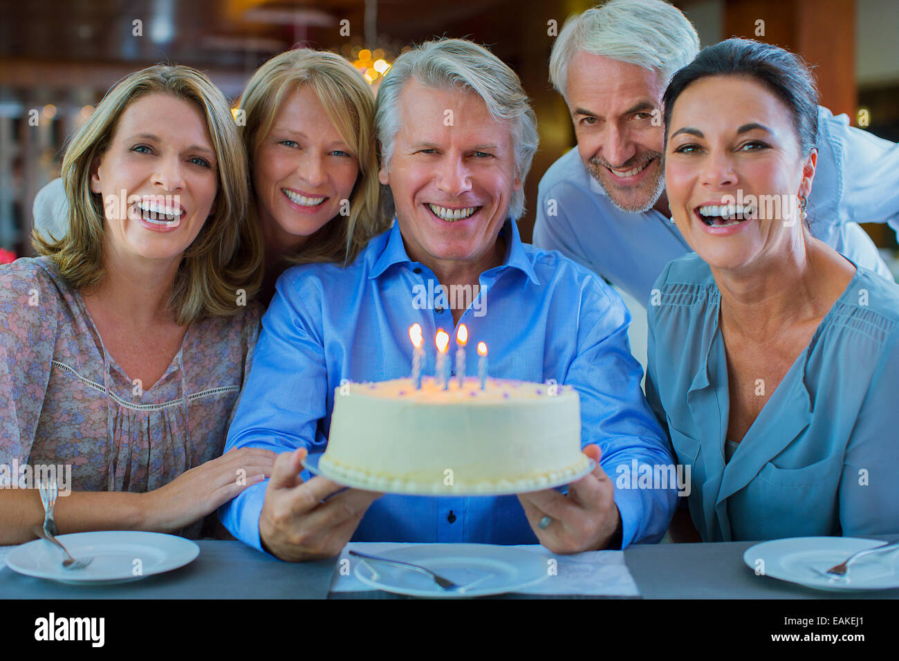 Porträt des Lächelns, reife Männer und Frauen mit Geburtstagstorte Stockfoto