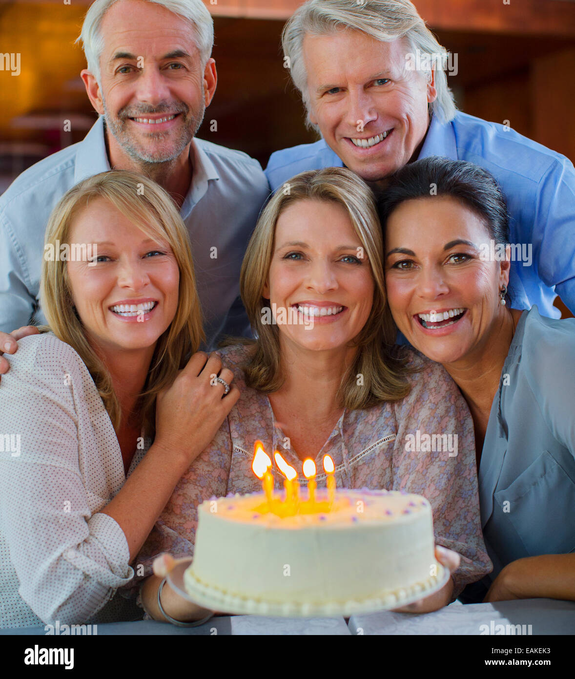 Porträt des Lächelns, reife Männer und Frauen mit Geburtstagstorte Stockfoto
