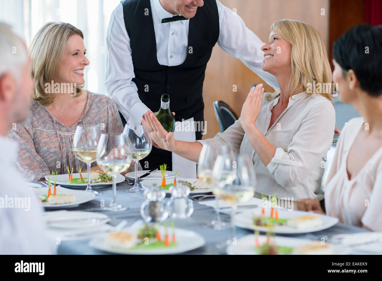 Kellner, die weiblichen Kunden am Tisch im Restaurant, Frau weigert Wein anzubieten Stockfoto