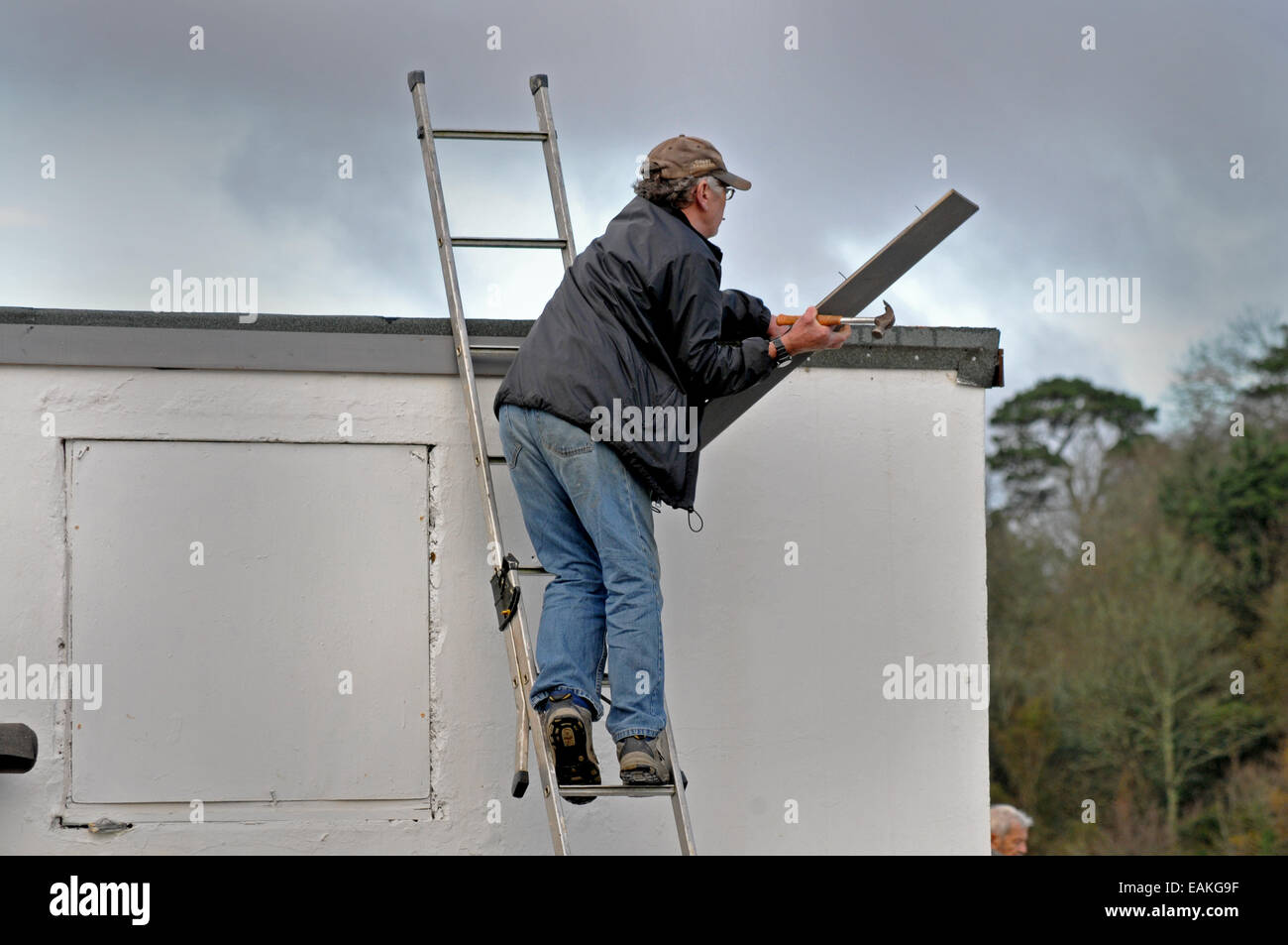Ein Mann, ein Dach zu reparieren Stockfoto