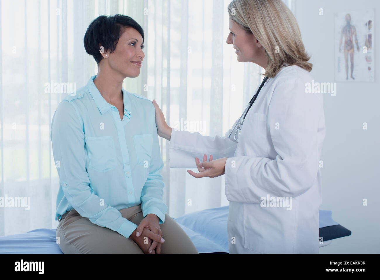 Lächelnde Ärztin im Gespräch mit Patienten im Büro Stockfoto