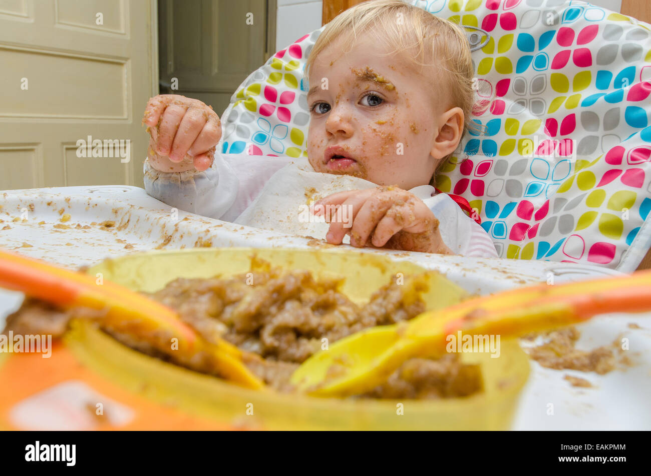 Ein kleinen Jungen (ca. 18 Monate alt) macht ein heilloses Durcheinander seine Mahlzeit. Stockfoto