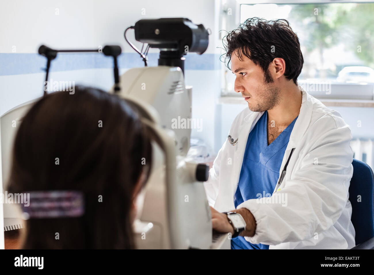 eine junge Augenarzt mit einem nicht-mydriatisch Netzhaut Kamera auf ein junges Mädchen Stockfoto