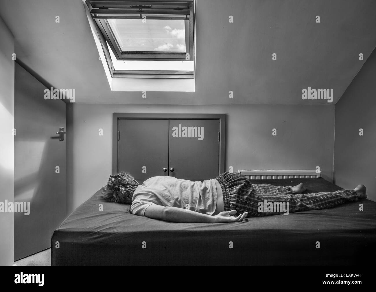 Ein Teenager in seinem Bett, während des Tages schlafen. Stockfoto
