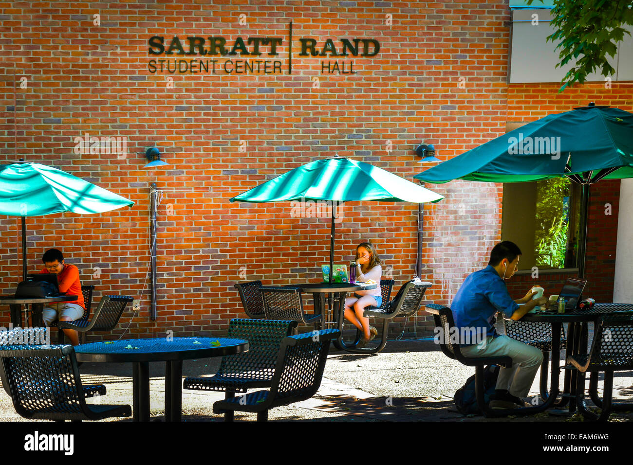 Studenten nutzen ihre Laptops draußen an Tischen mit Sonnenschirmen in Modena Student Center, Rand-Halle am Vanderbilt Univ Stockfoto