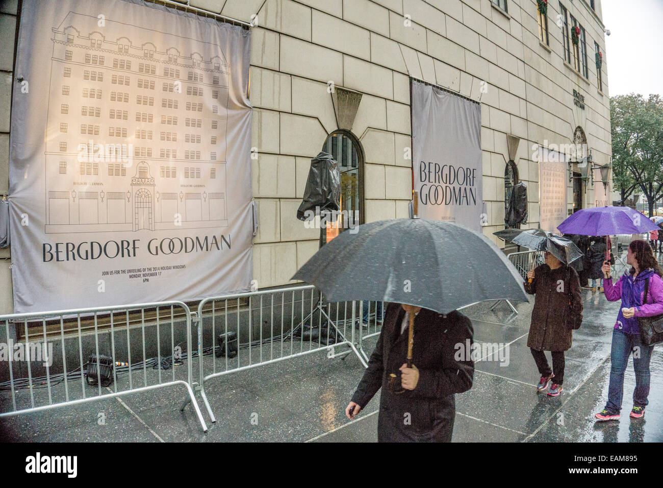 New York, USA. 17. November 2014; im strömenden Regen Passanten Einblick unter Sonnenschirmen auf verschleierte Bergdorf Goodman Weihnachtsfenster erwartet große Enthüllung auf 18:00 Credit: Dorothy Alexander/Alamy Live News Stockfoto