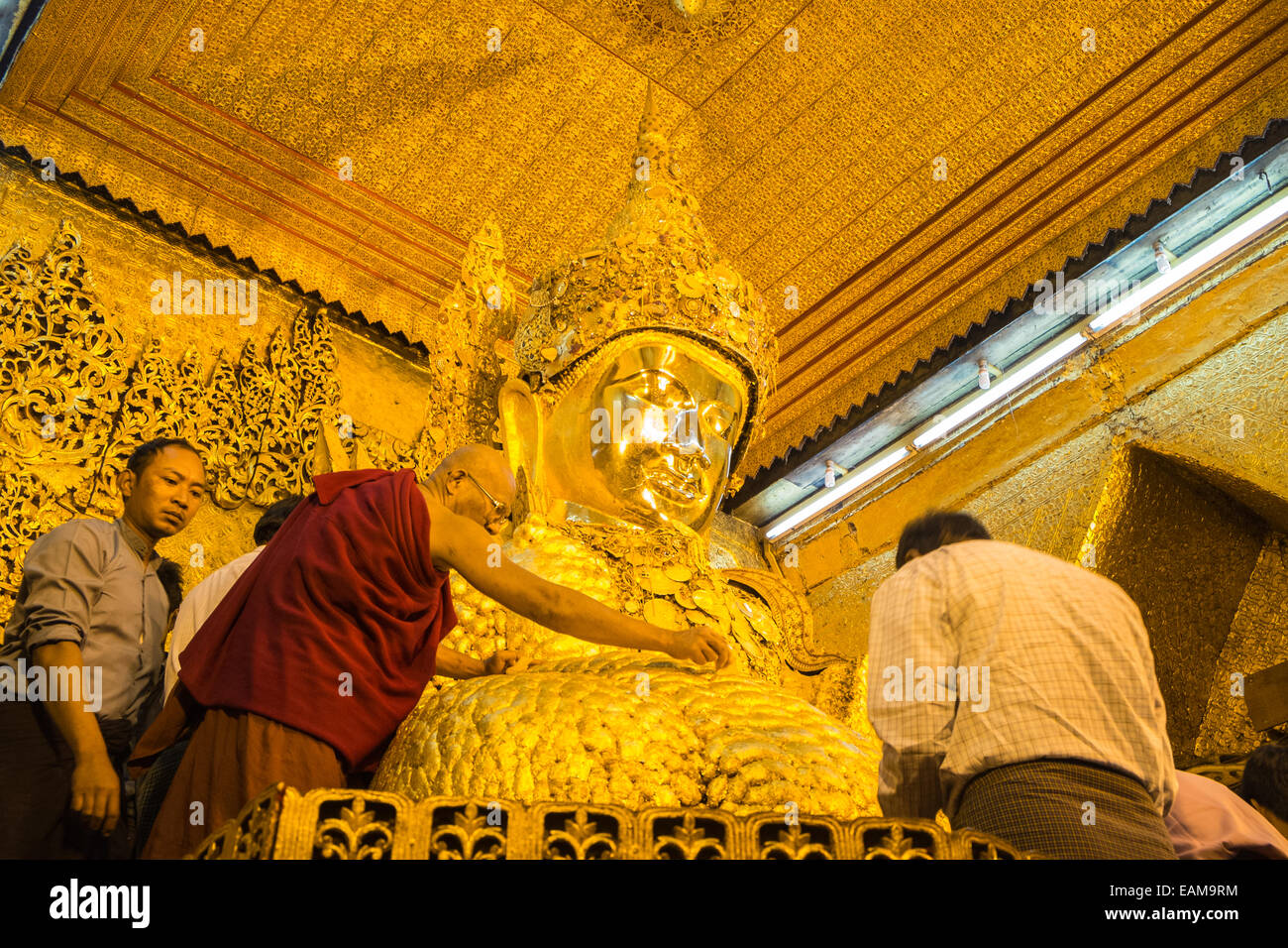 Anwenden von Blattgold auf riesigen goldenen Buddha, Mahamuni-Statue eines der am meisten verehrten Buddhas in Burma.Mandalay, Burma, Myanmar. Stockfoto