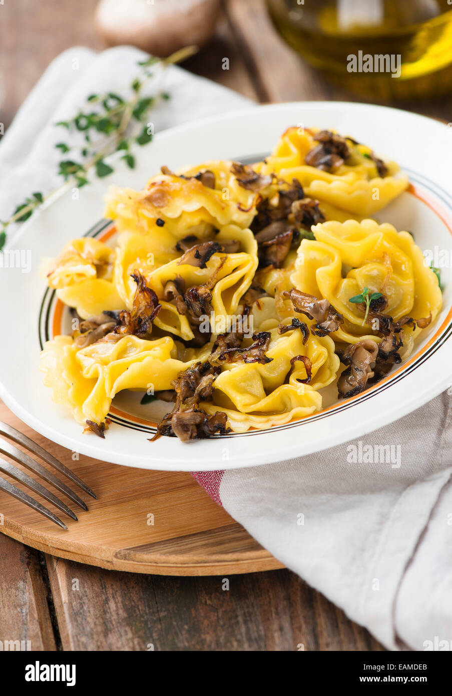 Tortelli Tortellini mit gegrillten Champignons und Zwiebeln Stockfoto