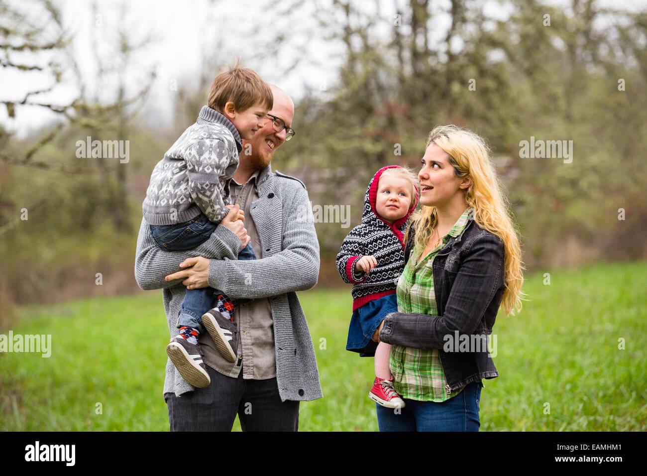 Lifestyle Portrait eine vierköpfige Familie mit Mutter, Vater, Sohn und Tochter Interaktion mit Glück. Stockfoto