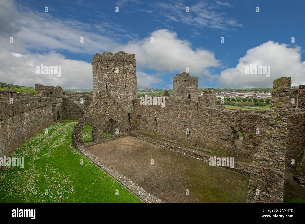 Blick vom hohen Steinmauer von riesigen Innenteil & Türme der Burg zerstörten 13. Jahrhundert Kidwelly mit Stadt in Ferne in Wales Stockfoto