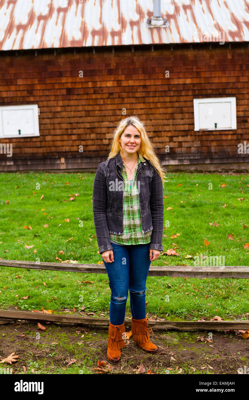Lifestyle Porträt einer Frau, die draußen mit einer Scheune im Hintergrund. Stockfoto