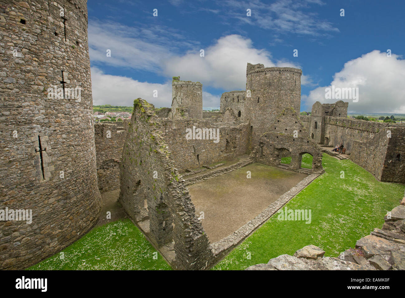 Blick vom hohen Steinmauer von beeindruckenden Innenteil & Türme des 13. Jahrhunderts Kidwelly Burgruine unter blauem Himmel in Wales Stockfoto