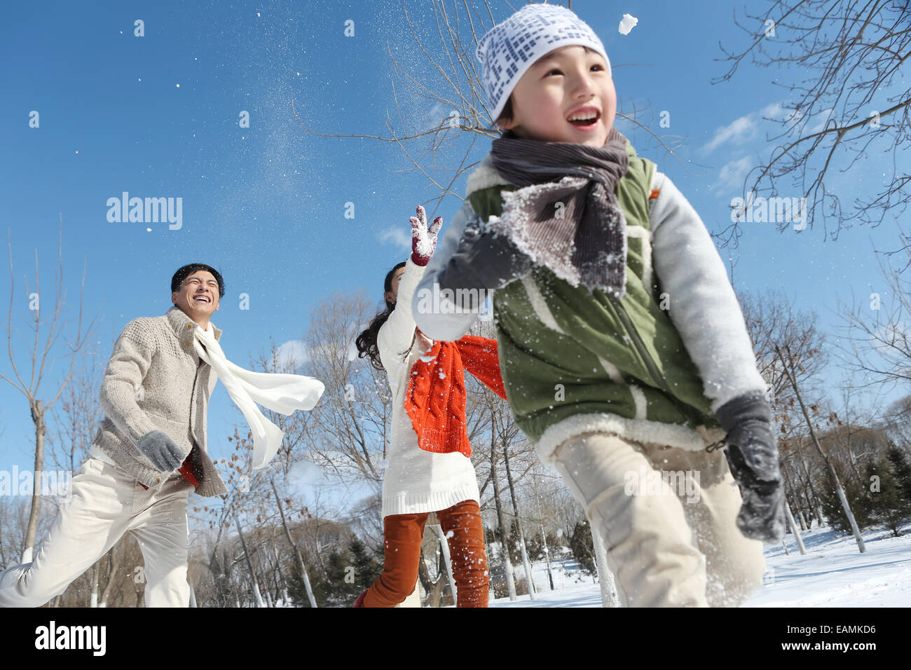 Eine Familie mit drei in den Schnee Schneeballschlachten Stockfoto