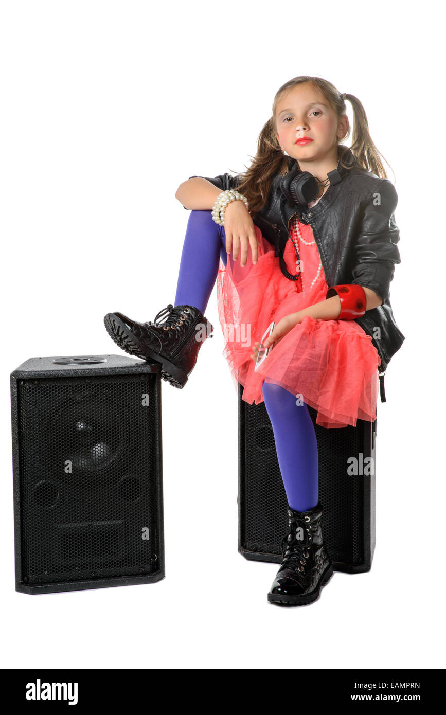 ein kleines Mädchen sitzt auf einem Lautsprecher auf weißem Hintergrund Stockfoto