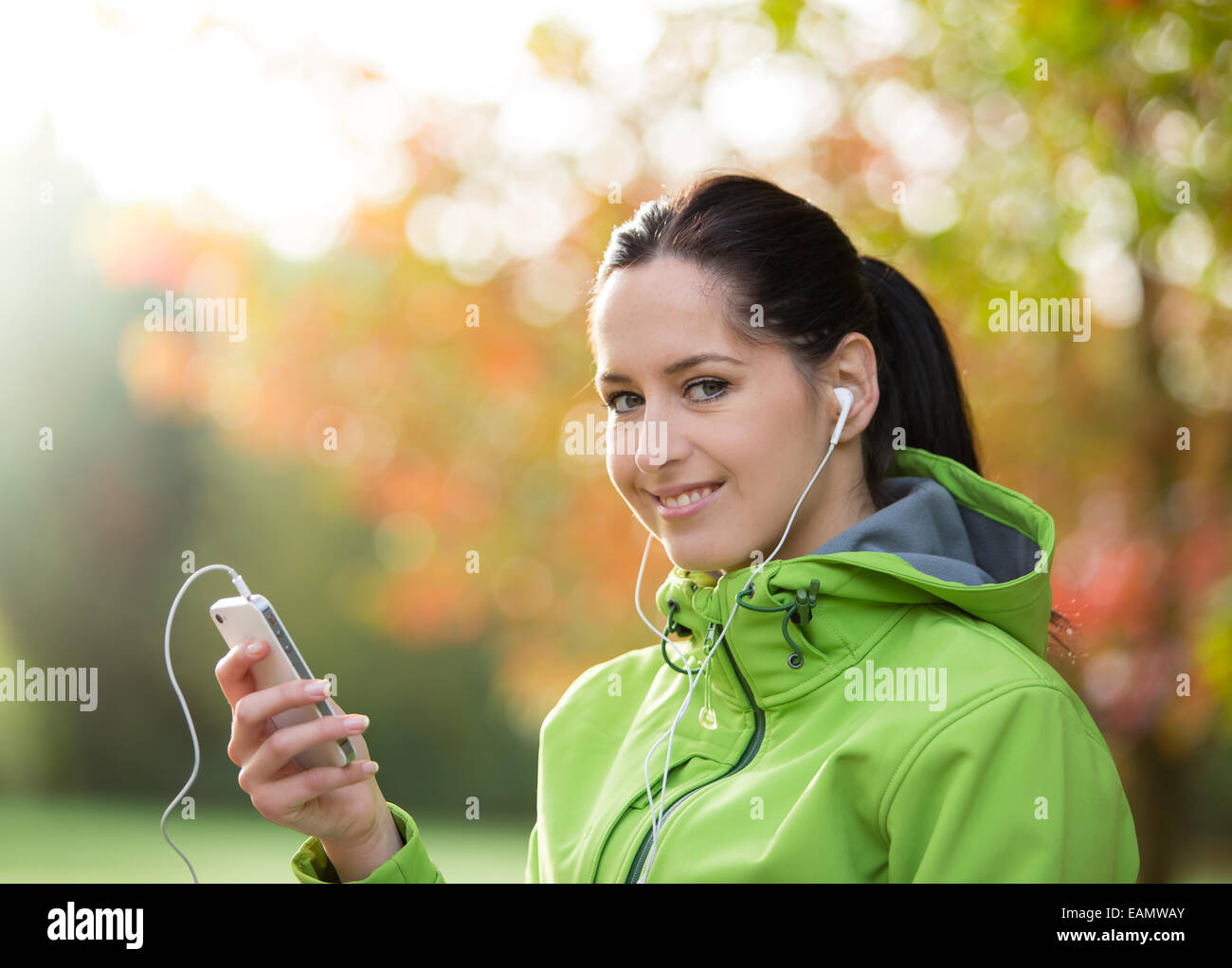 Junge Brünette glücklich Frau Musikhören im Herbst Park. Stockfoto