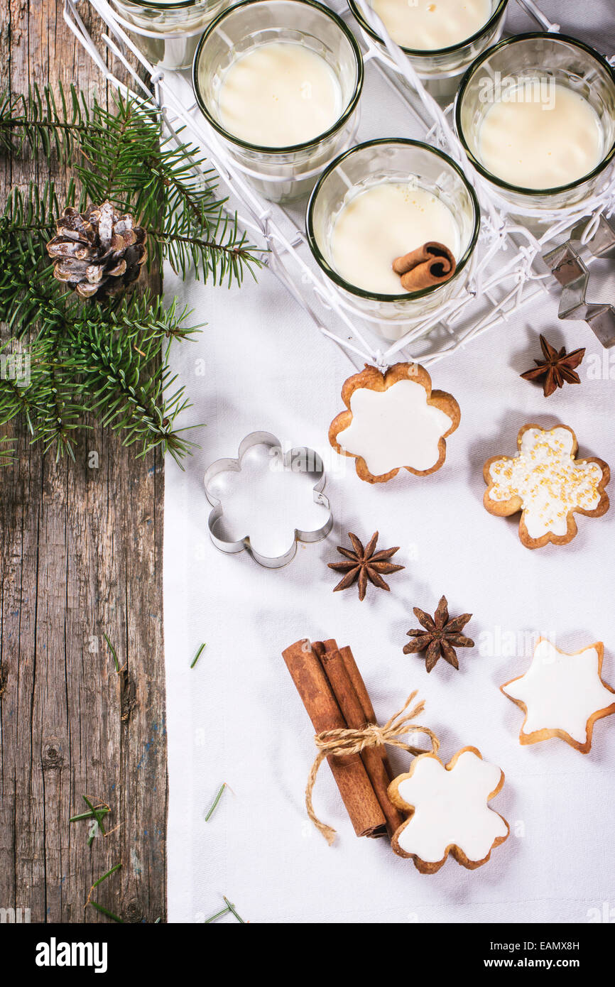 Weihnachtsplätzchen, die sortiert und Gläser Milch cocktail, serviert mit Weihnachtsbaum Zweig auf Holztisch. Stockfoto