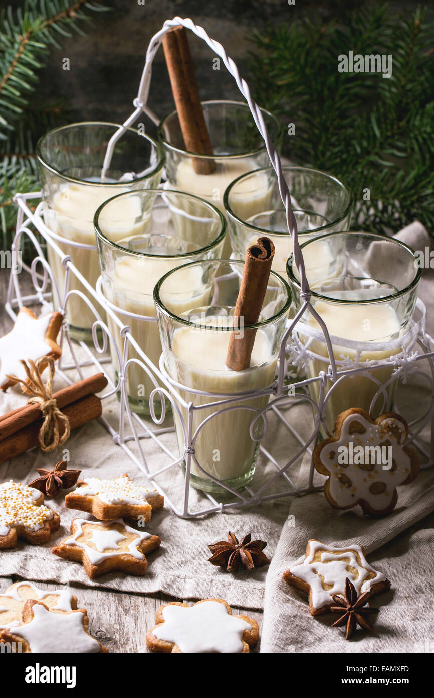 Weihnachtsplätzchen, die sortiert und Gläser Milch cocktail, serviert mit Weihnachtsbaum Zweig auf Holztisch. Stockfoto