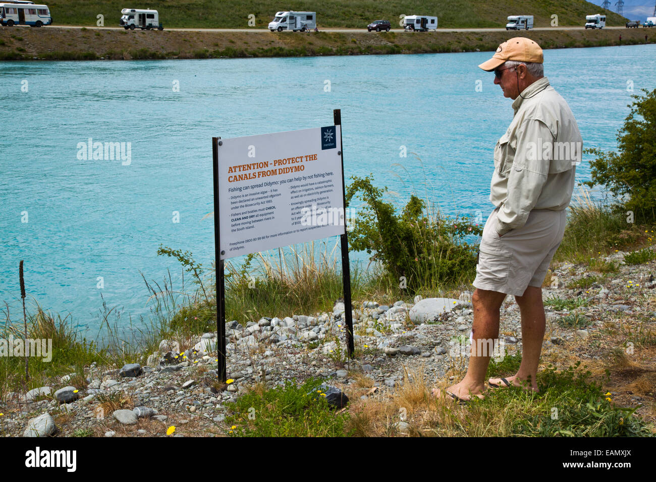 Neuseeland. Ein Tourist Fischer schaut ein Warnsignal Didymo Didymosphenia Geminata auf einem der Kanäle in Neuseeland Stockfoto