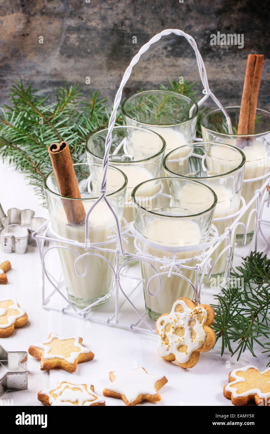 Weihnachtsplätzchen, die sortiert und Gläser Milch cocktail, serviert mit Weihnachtsbaum Zweig auf Holztisch. Stockfoto