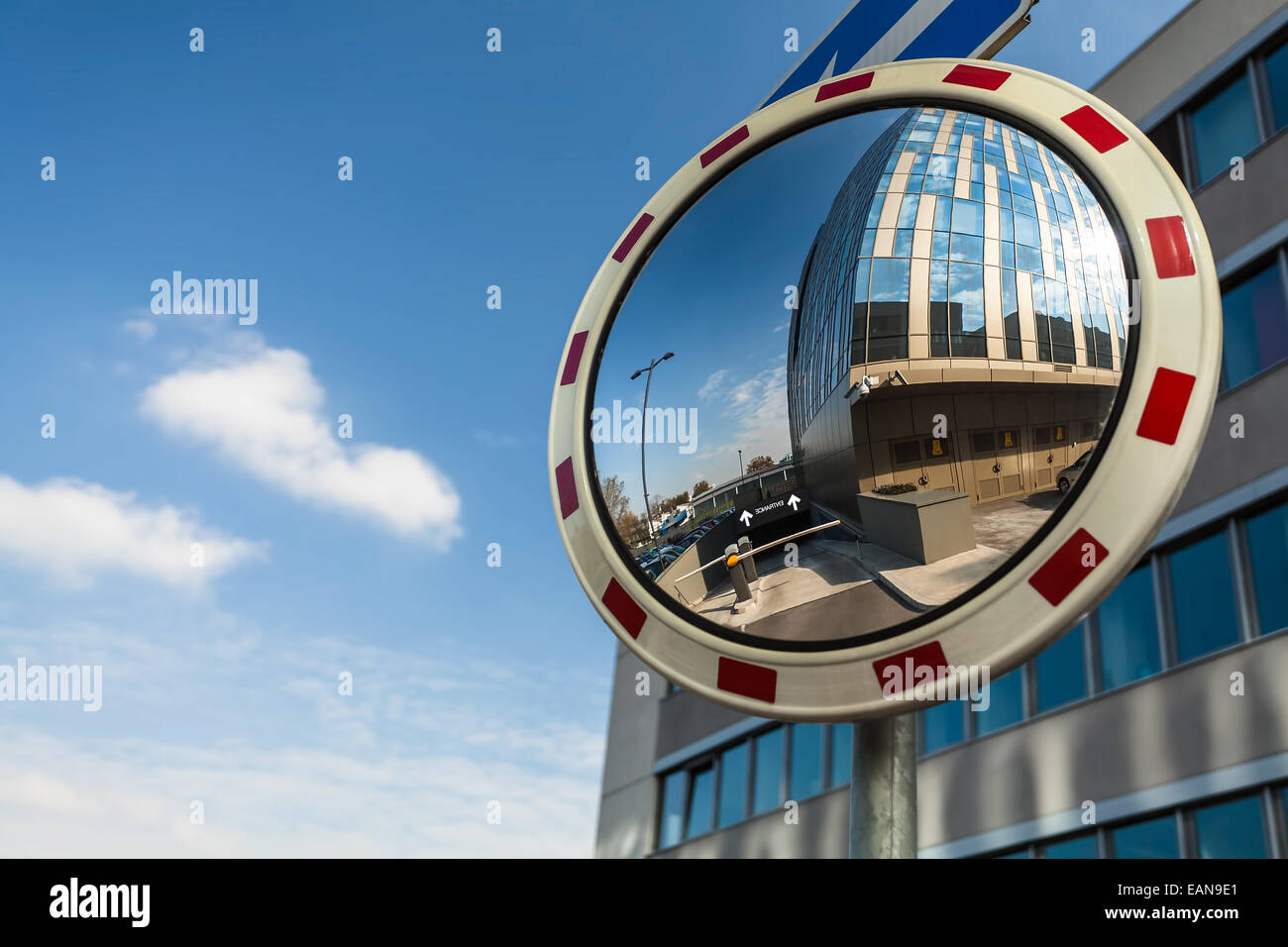 Konvexe Spiegel an einer Straßenecke reflektieren einen Barriere Eingang in Tiefgarage Stockfoto