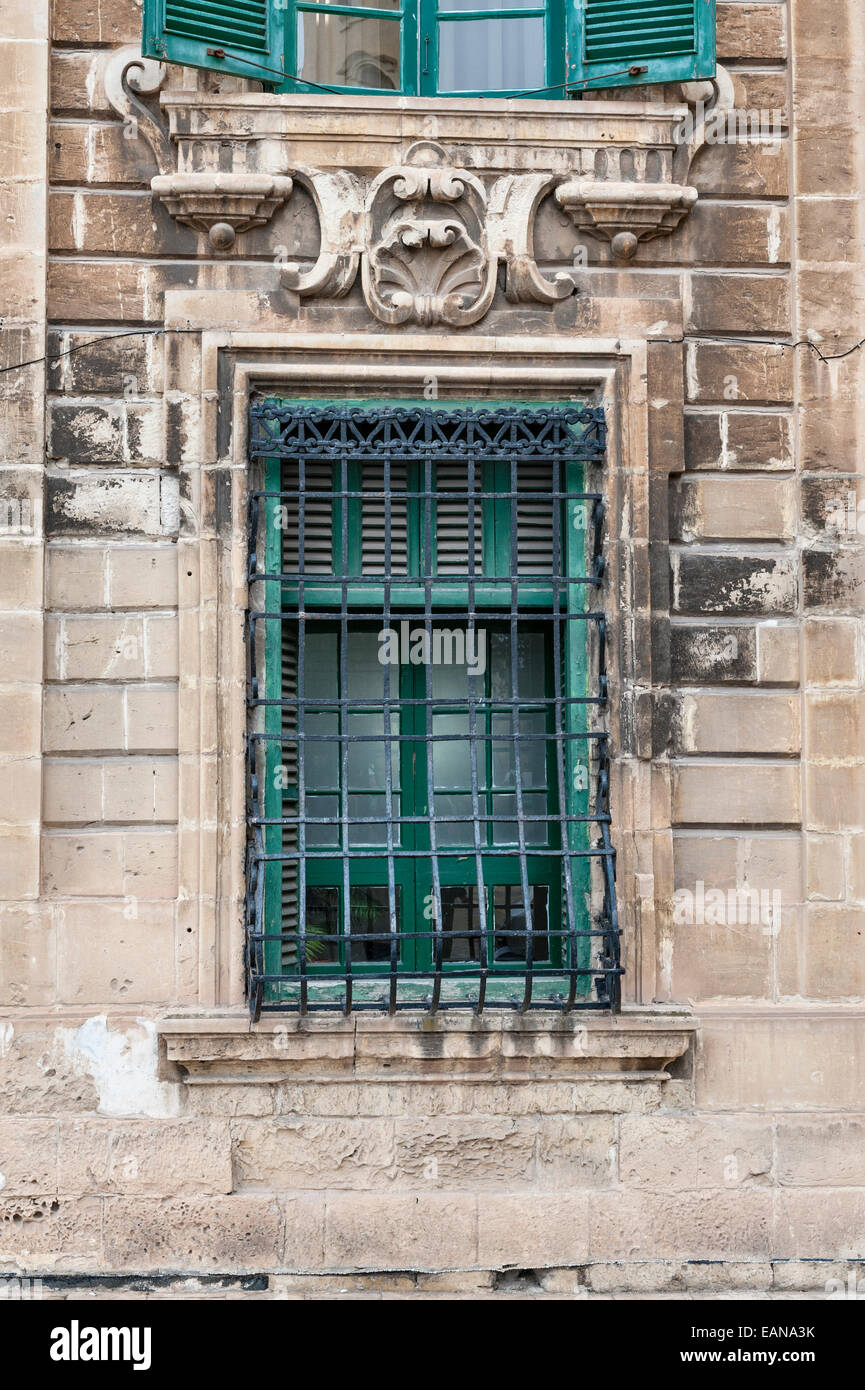 Ein vergittertes Fenster auf einem alten Haus in Valletta, Malta Stockfoto