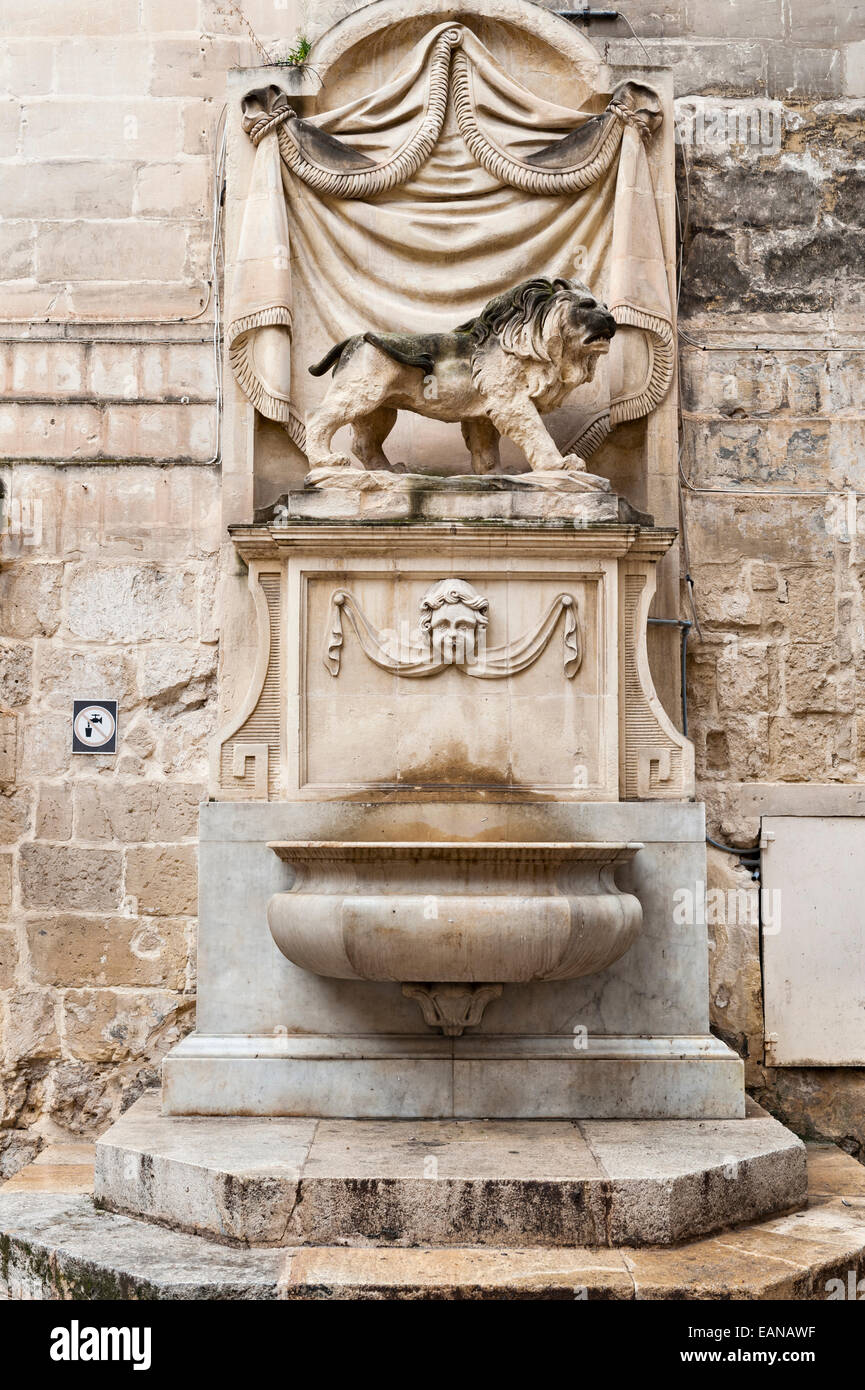 Der kaiserliche britische Löwe steht über einem öffentlichen Trinkbrunnen in einer Straße in Valletta, Malta Stockfoto