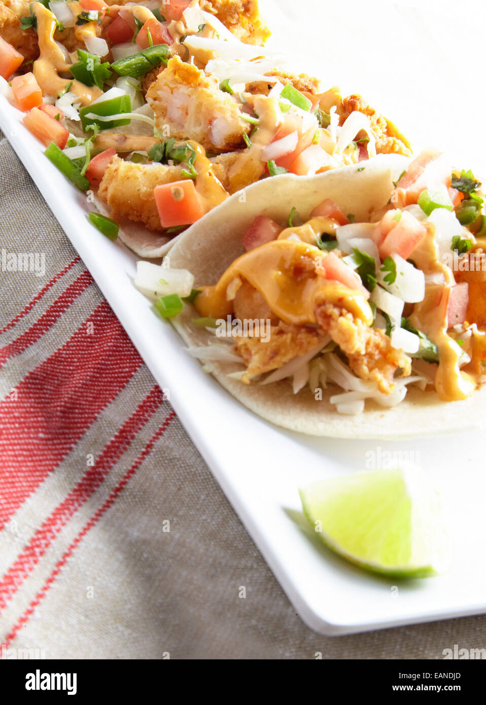 Shrimp Tacos auf einem roten und weißen Teller Stockfoto