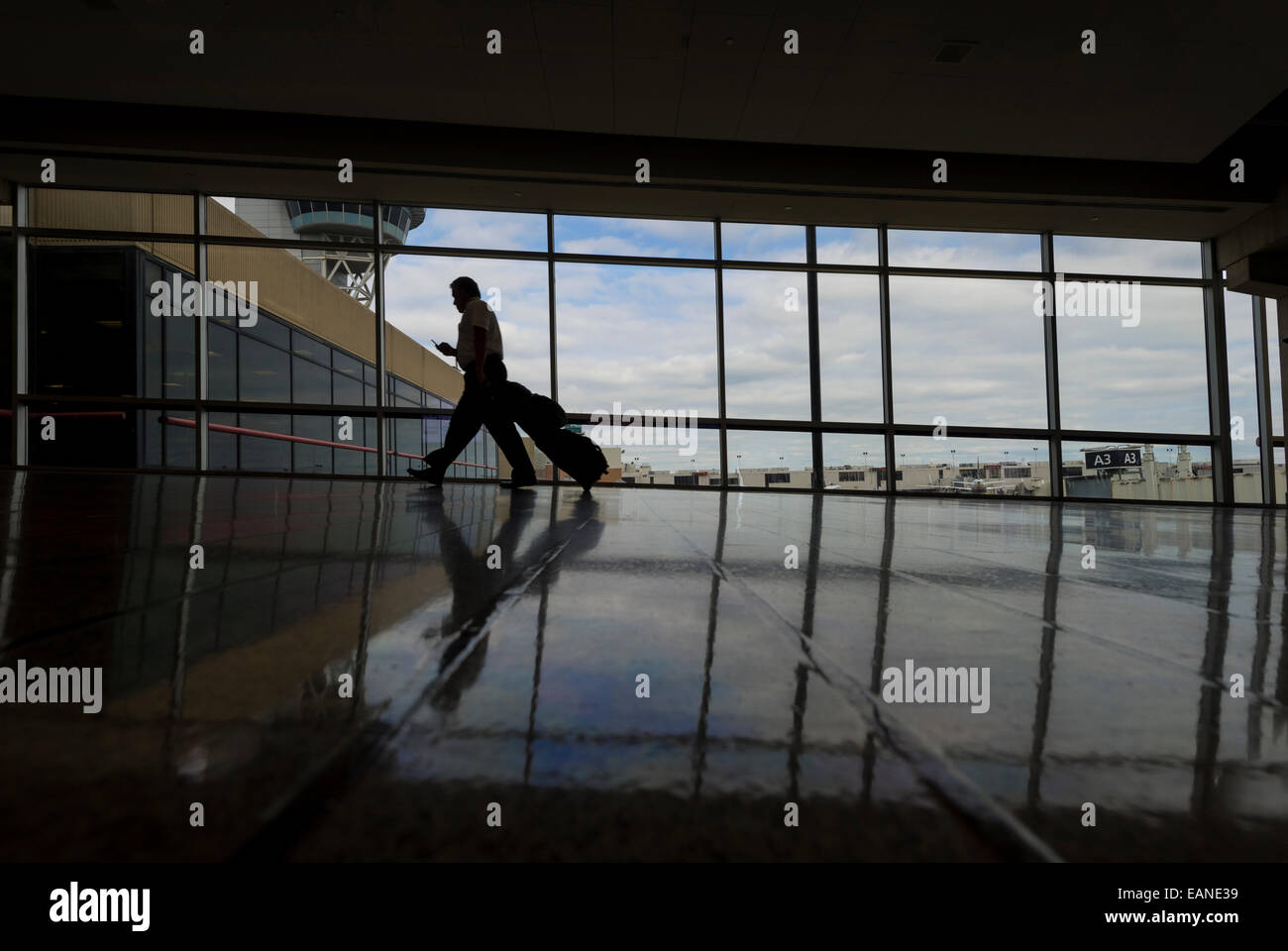 Reisender Geschäftsmann E-Mails auf Handy im Flughafen, Philadelphia USA Stockfoto