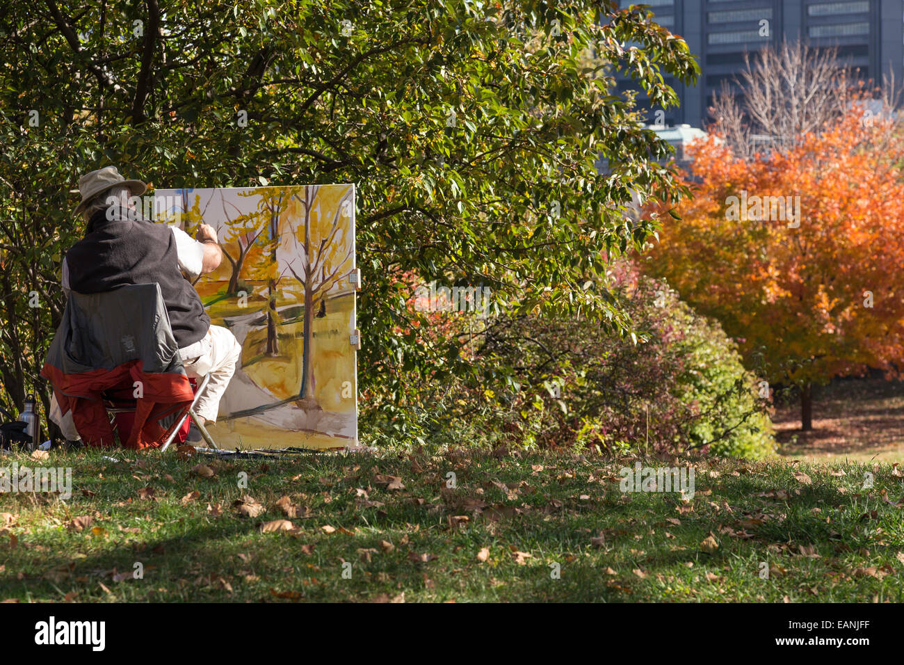 Ein reifer männlicher Maler arbeitet auf einer Staffelei, Central Park, NYC Stockfoto