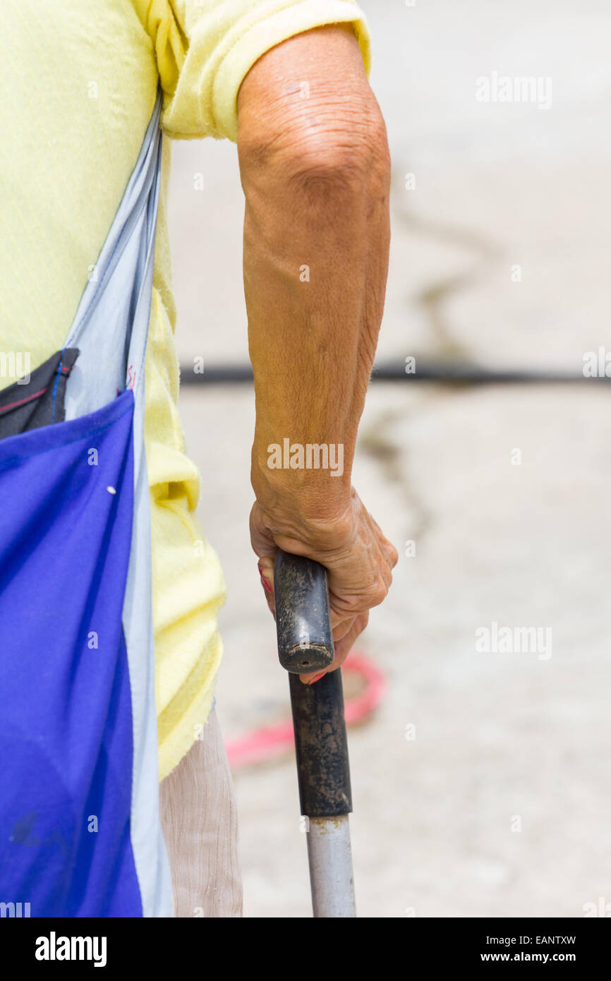 Alte Frau Hand stützt sich auf Gehstock, close-up Stockfoto