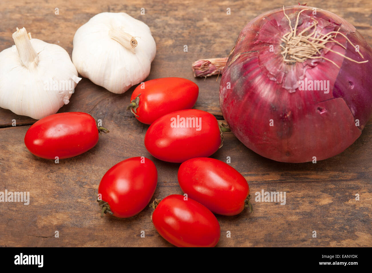 Zwiebel Knoblauch und Tomaten Grundlagen der italienischen Küche auf rustikalen Tisch Stockfoto