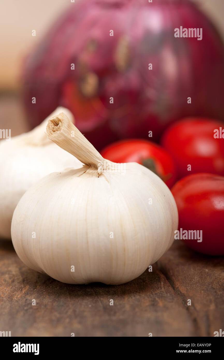 Zwiebel Knoblauch und Tomaten Grundlagen der italienischen Küche auf rustikalen Tisch Stockfoto